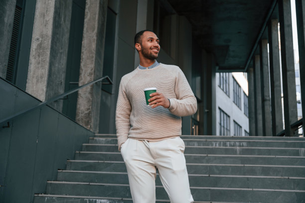 还有一杯饮料。英俊的黑人男子在商业大楼附近的户外图片下载