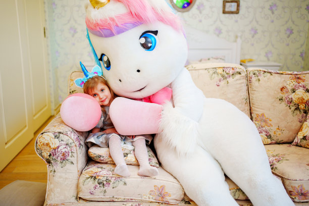 可爱的小女孩和一个穿着独角兽服装的动画师。图片下载