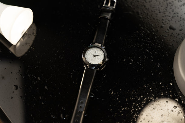 手表放在黑色玻璃桌上。时尚手表照片。水滴在桌子上。奢侈手表。时钟图片下载