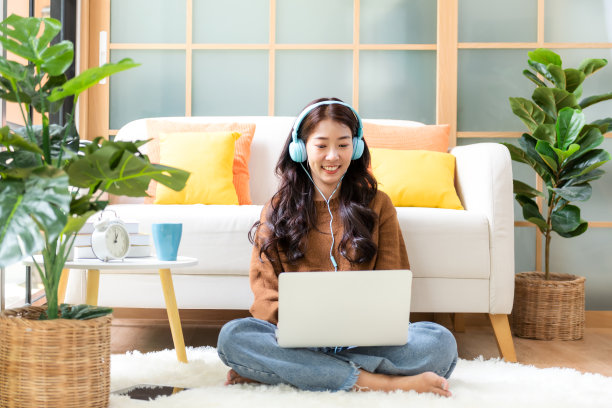 快乐的年轻女性在家里工作和在线会议。生活方式自由职业者放松和放松喝咖啡在客厅，图片下载