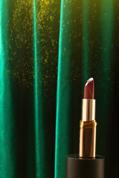 一支口红在绿色窗帘天鹅绒背景。圣诞模拟，模板或海报的广告口红。图片下载
