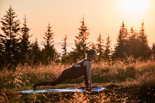 迷人的女人在黎明做战士的一个姿势。图片下载