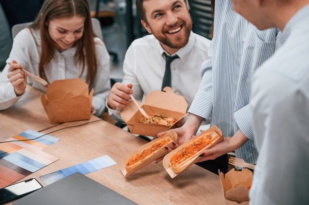 聊天，休息。一群同事一起在办公室吃环保盒里的食物图片下载