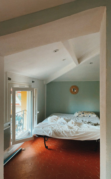 卧室的室内照片，展示了硬木地板和通往门廊的敞开的门图片下载