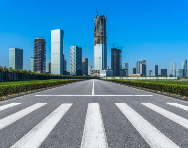 空旷的道路，斑马线和现代城市的摩天大楼图片下载