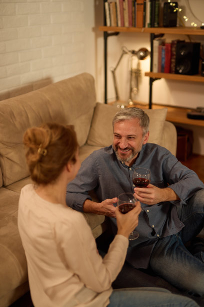 浪漫成熟的情侣在家里放松，喝红酒图片下载