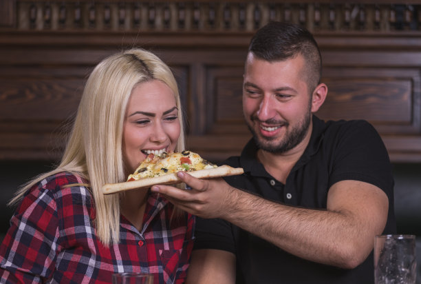 幸福的情侣在酒吧分享披萨图片下载