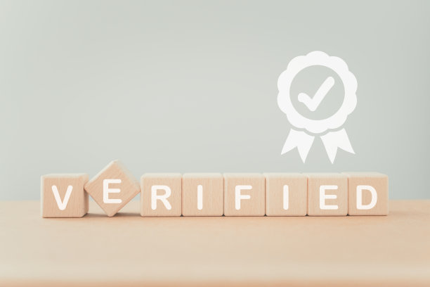 木制方块上有白色保证标志的验证字，用于产品服务的质量控制，批准，保证和保修认证概念图片下载