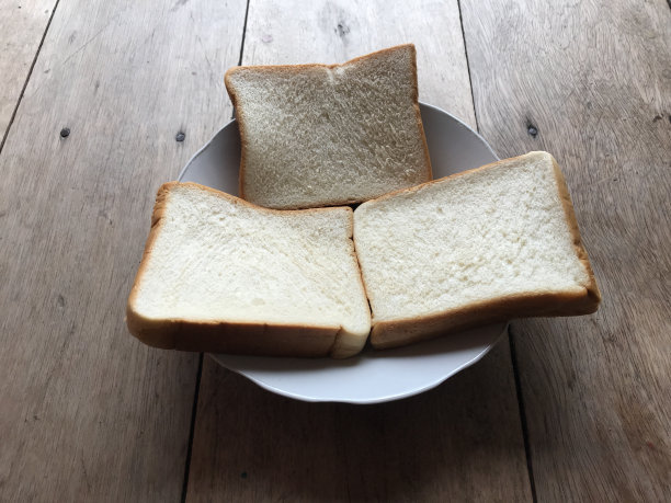 面包在木质背景上。乡村黑麦。新鲜的面包的乡村传统的木质纹理背景。面包店有硬皮面包。烘焙产品标签、设计等设计元素图片下载