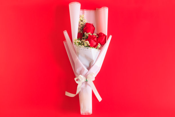 红玫瑰花束，红色背景上点缀着白花，情人节和特殊日子的花束图片下载