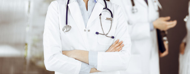 无名年轻女医生双臂交叉站在诊所里。冠状病毒大流行期间的医学概念图片下载