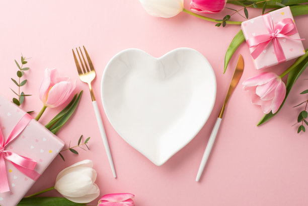母亲节的概念。顶部视图照片心形盘叉刀时尚礼盒彩带蝴蝶结和郁金香在孤立的粉彩粉红色背景与复制空间图片下载