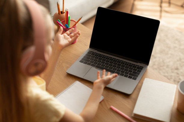 小女孩在室内用空屏幕的笔记本电脑视频通话图片下载