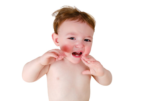 一个嗷嗷待哺的小男孩躺在床上，孤零零地躺在白色的背景上。不开心的孩子特写在白色毯子上，孤立在白色背景上。一岁儿童图片下载