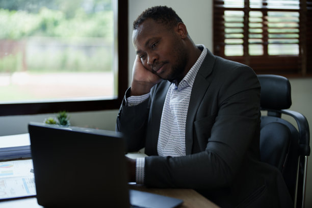 精疲力竭美国非洲商人在压力工作与许多文书文件，偏头痛发作，自由职业者，在家工作图片下载