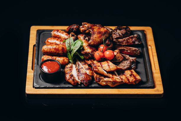 肉放在木板上。炸鸡翅，排骨，烤蔬菜，炸薯条。啤酒开胃酱背景图片，复制空格文字图片下载