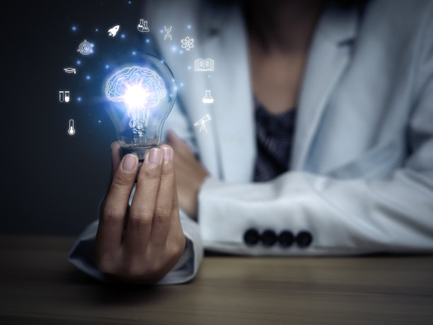 老师手持电灯泡毕业帽，互联网教育科学课程学位，学习知识以创意思维理念。E-learning研究生证书课程教育经营理念。图片下载