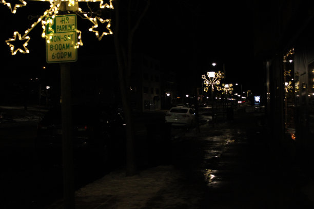 市中心被建筑物包围的灯火通明的街道图片下载