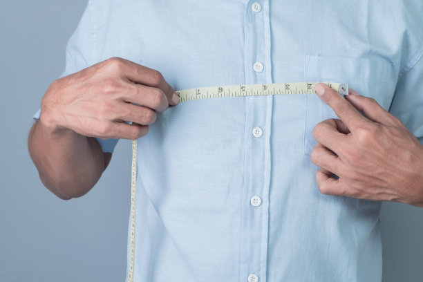 一个男人用卷尺测量他胸部的宽度图片下载