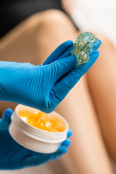 美容师手里拿着糖膏。图片下载