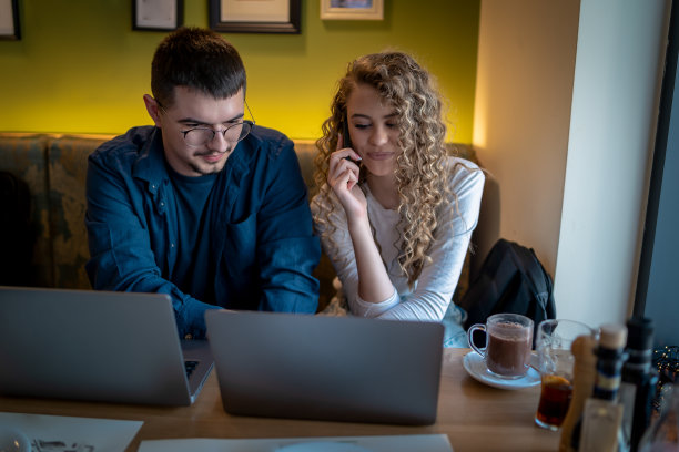 Business people working together at a café using their laptops图片下载