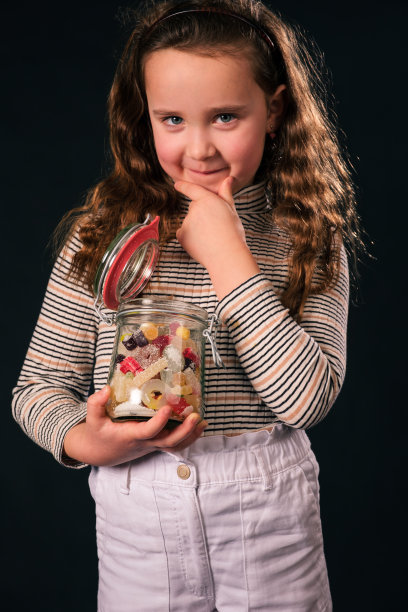 8岁女孩拿着糖果罐的肖像图片下载