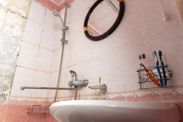 一间又脏又破的浴室，瓦片掉了。破旧的浴室图片下载