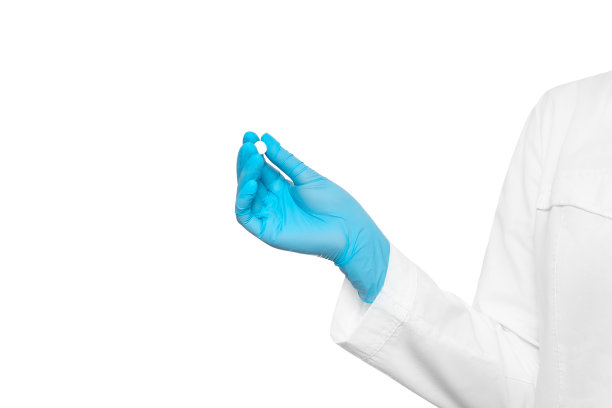 穿着医用长袍和手套的医生递给我一粒药丸图片下载