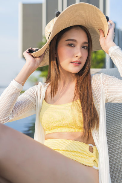 放松夏天休闲休闲亚洲女性女性在泳装上凉爽的藤条泳池长椅上躺在游泳池附近，无边泳池边在建筑物的屋顶上，夏天旅游度假日光浴图片下载