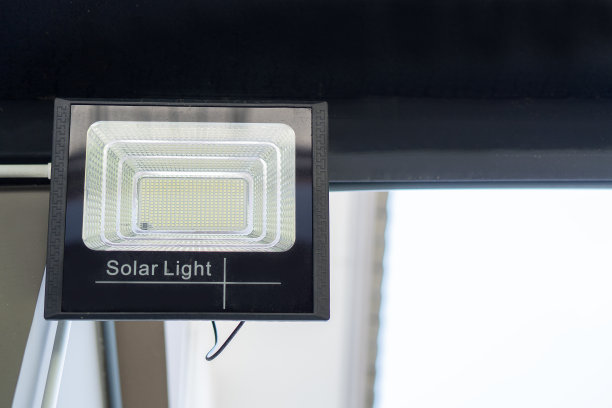 LED射灯和太阳能电池板在房子外面的墙与阳光。图片下载