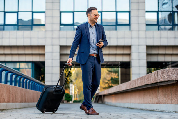 时髦的商人带着行李箱去旅行。运输的概念图片下载