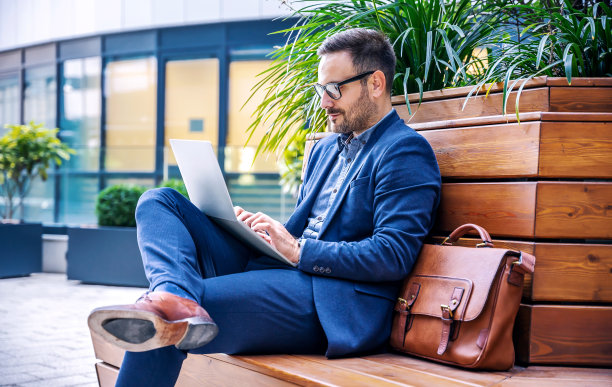 业务人员。商人在办公室前通过笔记本电脑检查数据。商业、生活方式概念图片下载