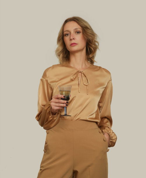 系列工作室照片的年轻女模特穿着金色米色丝绸长袖衬衫图片下载