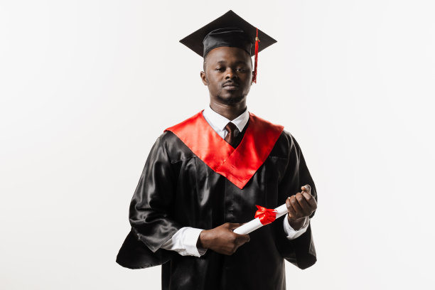完成大学。自信的非洲男子学士毕业长袍和帽子上的白色背景。快乐和有趣的非洲毕业生男子微笑。学生在大学取得硕士学位，图片下载