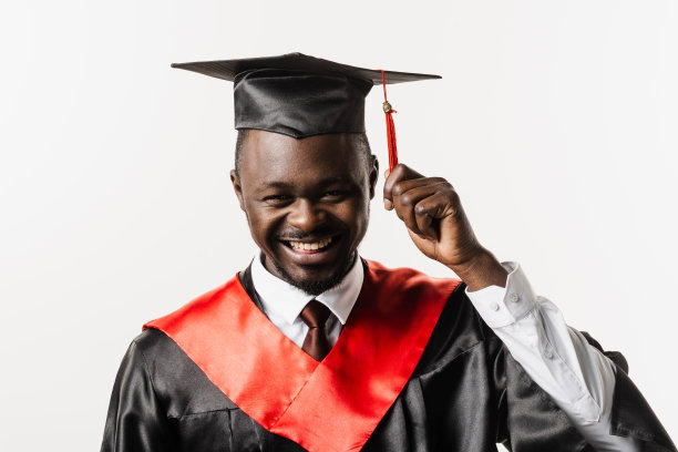 研究生肖像非洲人大学毕业并获得硕士学位。毕业典礼。快乐的非洲男子在黑色毕业长袍是微笑在白色背景。图片下载