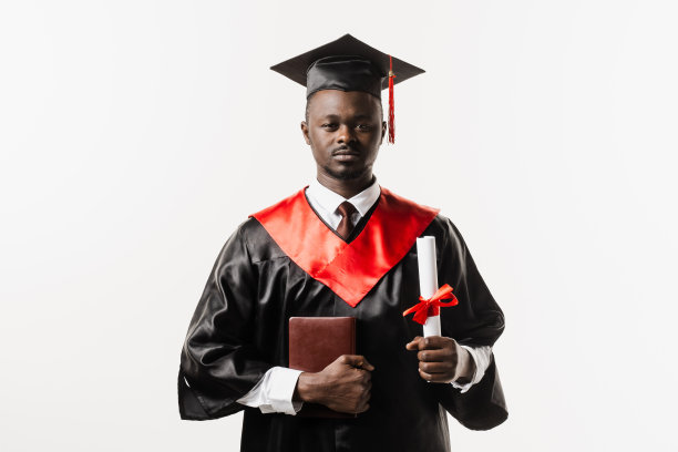 毕业生非洲人大学毕业，获硕士学位。毕业典礼。快乐的非洲男子微笑着，手里拿着白色背景的荣誉文凭。图片下载
