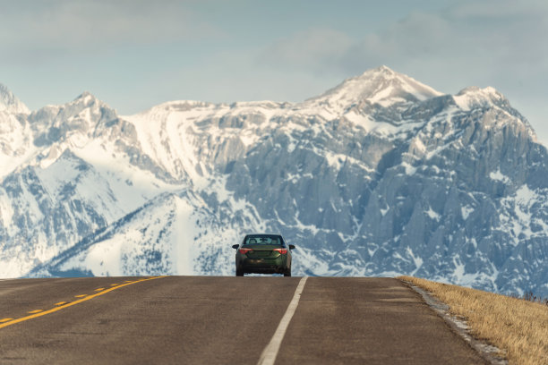汽车行驶在以大山为背景的路上图片下载