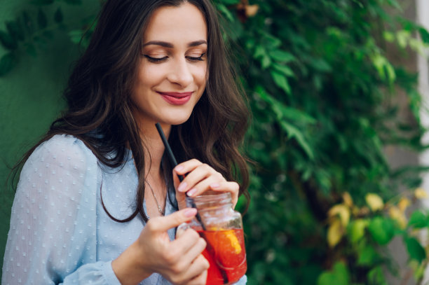 一个女人坐在街边咖啡馆里喝冷饮图片下载