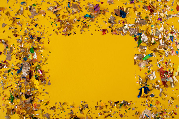 黄色的桌子上有彩色的纸屑图片下载