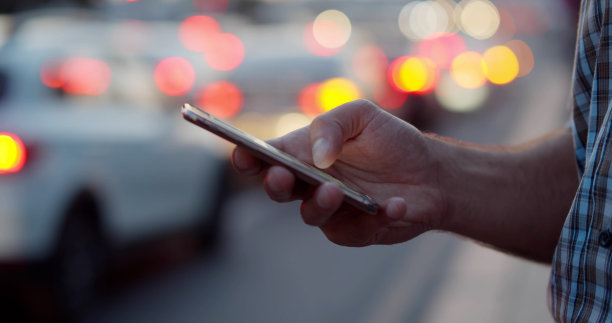 男子在城市街道上拿着智能手机的镜头图片下载