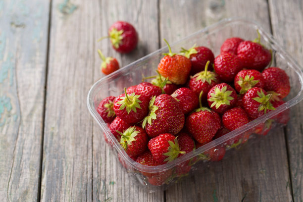 多汁成熟的红色草莓装在塑料容器里图片下载