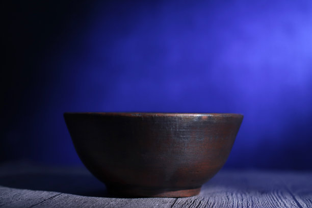 空陶罐碗下的灯光与黑暗的背景图片下载