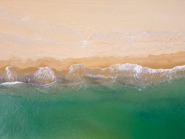 沙滩和大海的自上而下鸟瞰图是一个令人惊叹的景象，从独特的角度揭示了海岸线的自然之美。图片下载