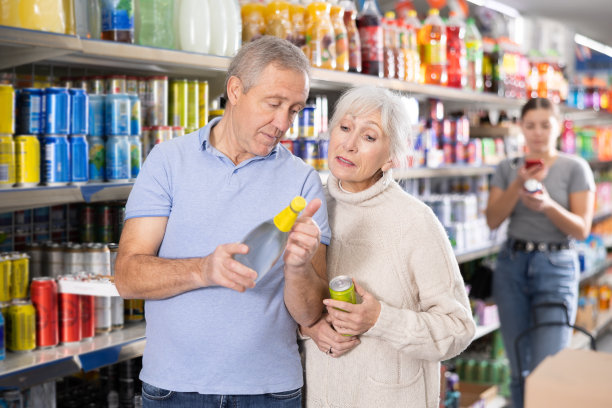 老年妇女和男子在杂货店选择软饮料图片下载