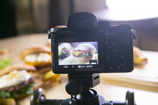 一个人正在用相机拍摄桌子上的食物和饮料。图片下载