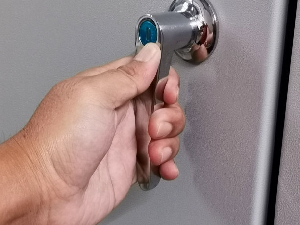 在低压配电板上用钥匙合上门把手的照片。图片下载