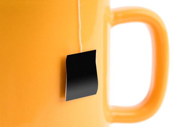 玻璃杯与茶包隔离在一个白色上。图片下载