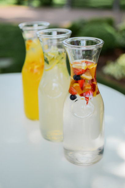 夏日柠檬水加水果。在阳光下的白色桌子上喝酒。夏日，热带，新鲜鸡尾酒概念。图片下载