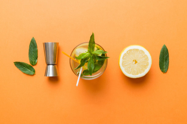 凯匹林纳，莫吉托鸡尾酒，伏特加或苏打饮料与莱姆，薄荷和稻草的桌子背景。清爽的薄荷和酸橙饮料在玻璃顶视图平铺图片下载