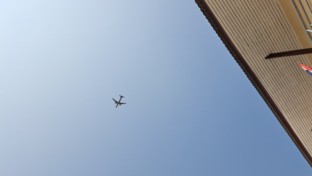 商用飞机在蓝色的云景天空中飞行。底视图图片下载